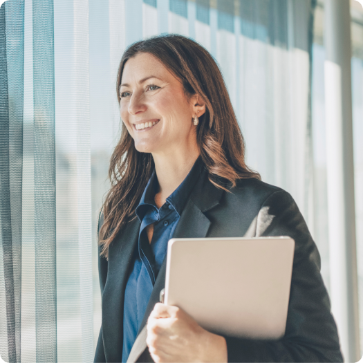 Businesswoman holding laptop in modern office setting
